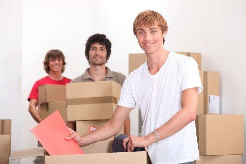 Two movers handling a heavy item with proper lifting technique